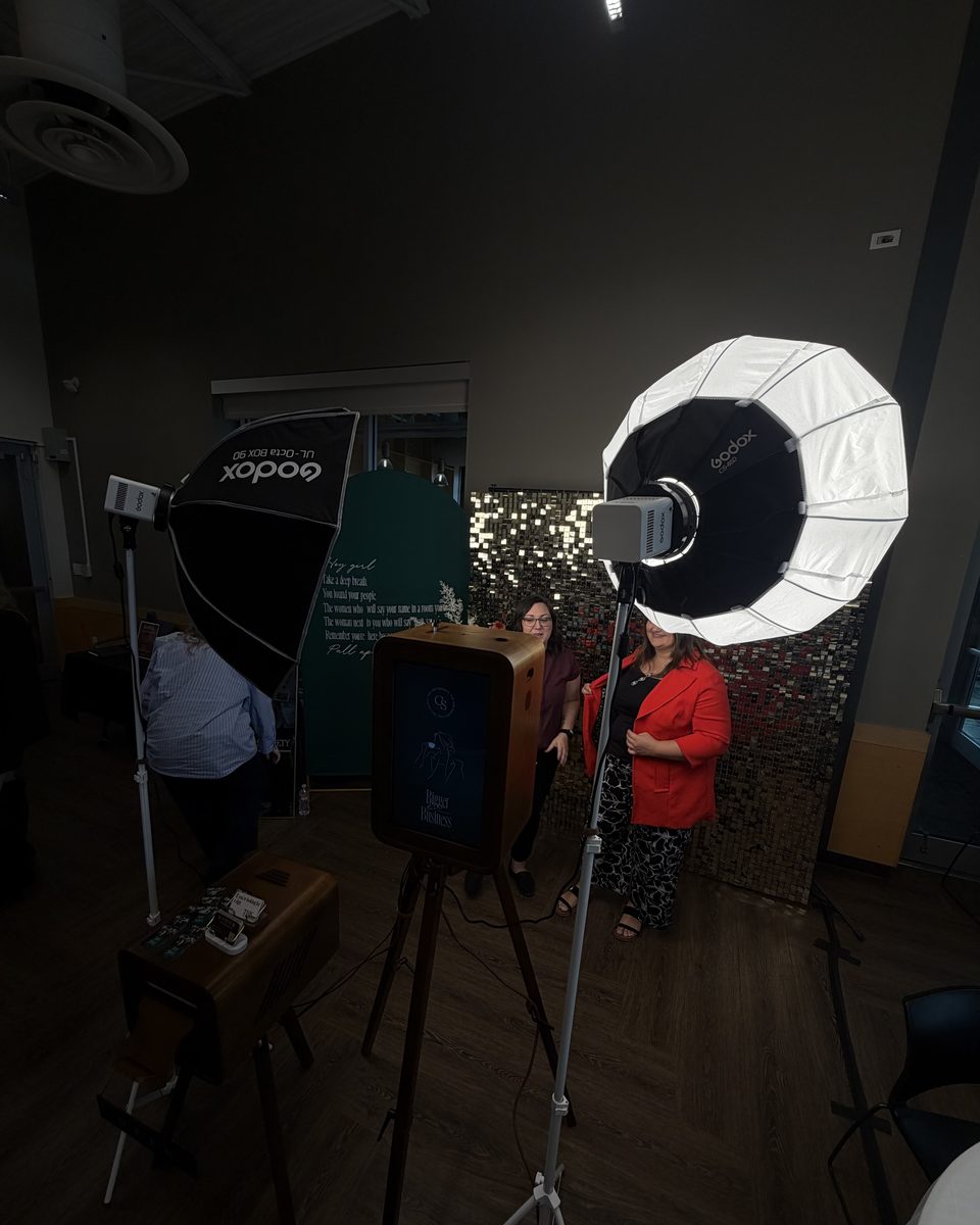 Two guests posing at the booth in a darkened room, lit by the softbox